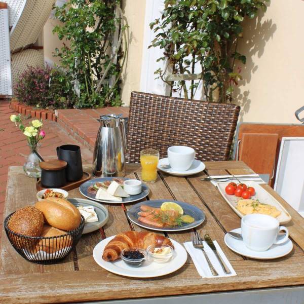 Gäste genießen Pfingsten auf Amrum im Hotel Hüttmann bei Sonnenschein, regionalem Essen und entspannter Inselatmosphäre.